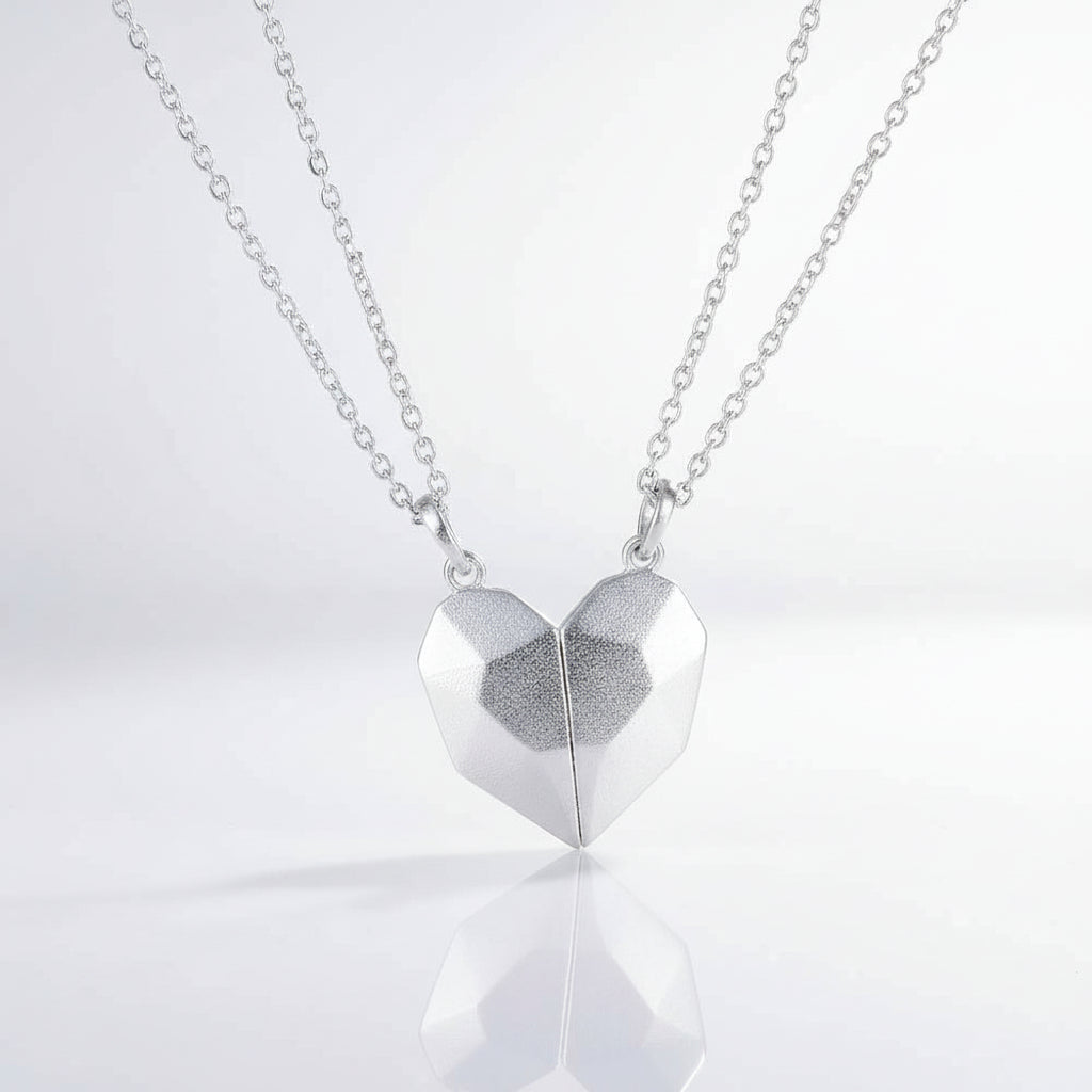 Silver heart-shaped pendant on a chain against a white background