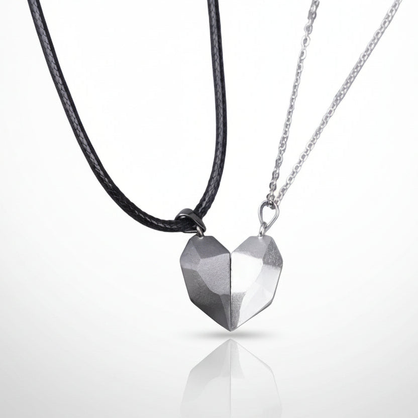 Two heart-shaped pendants on black and silver necklaces against a white background