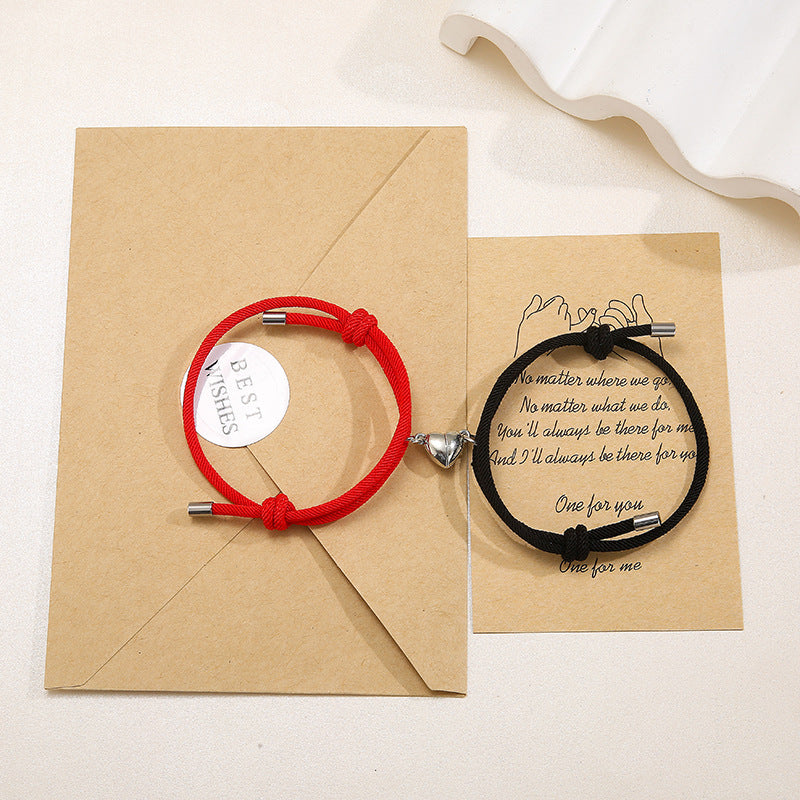 Two bracelets, one red and one black, on brown paper with a message card.