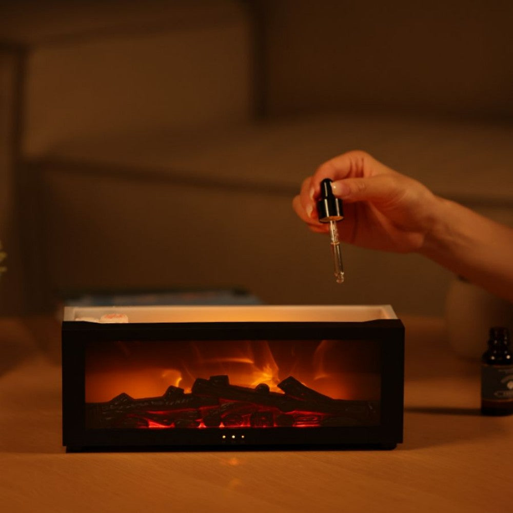 Hand holding a dropper over a small electronic device with a fire simulation, in front of a blurred indoor setting.