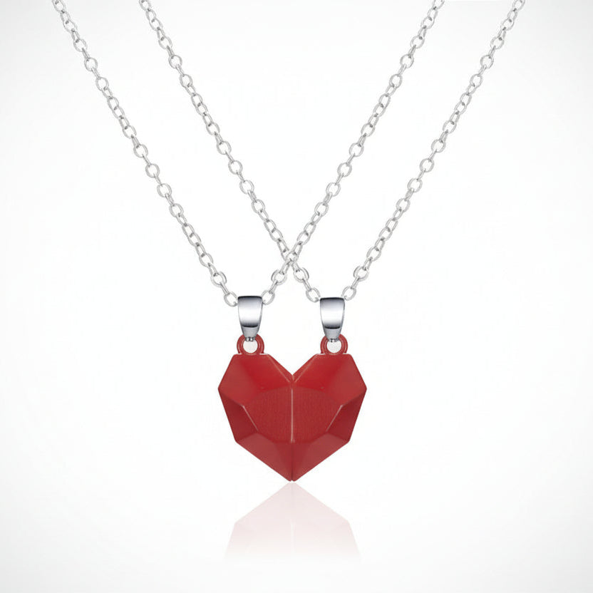 Red heart-shaped pendant on a silver chain against a white background