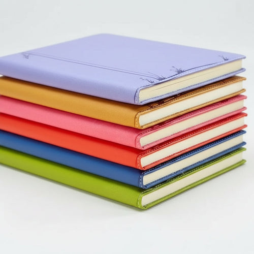 Stack of colorful notebooks with visible stitching detail on a light background