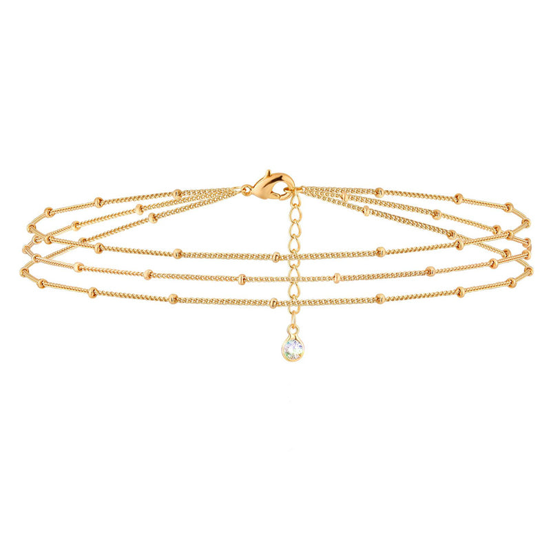 Gold chain necklace with a small pendant on a white background