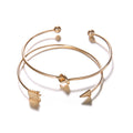 Gold bangles with geometric designs on a white background