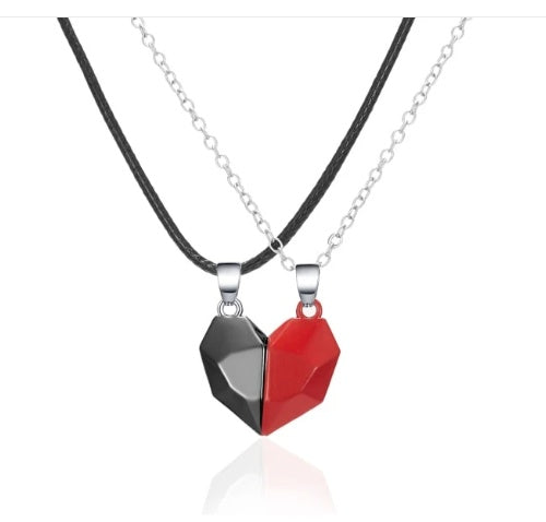 Two heart-shaped pendants, one black and one red, on silver chains against a white background.