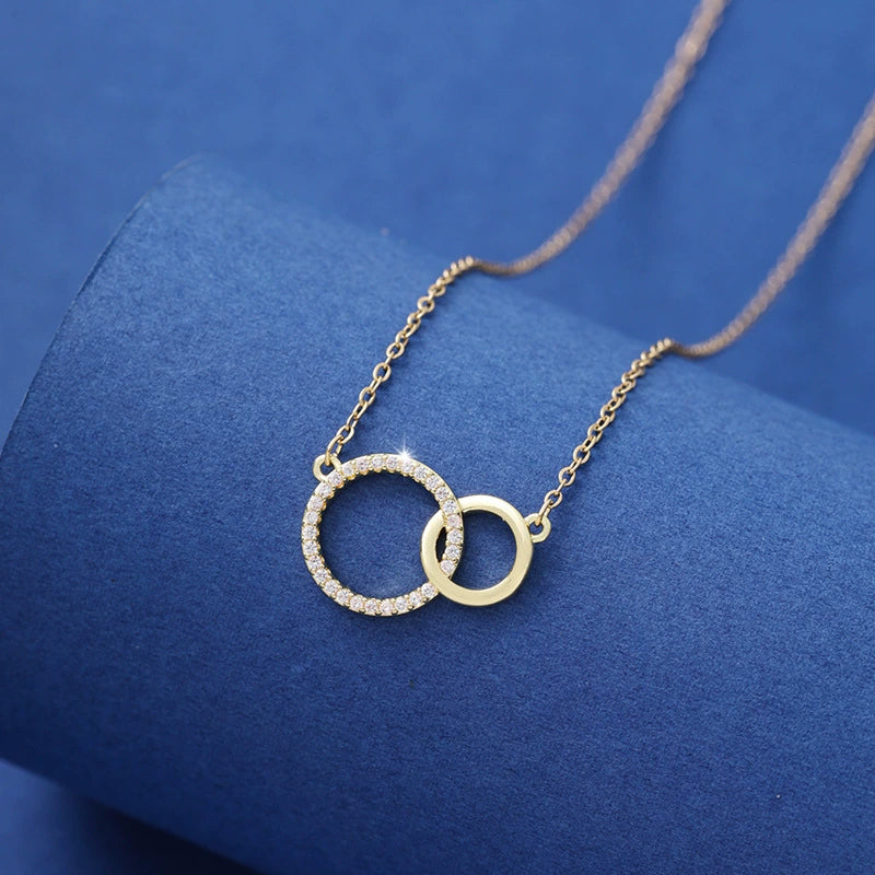 Gold necklace with interlocking rings on a blue background
