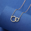 Gold necklace with interlocking rings on a blue background