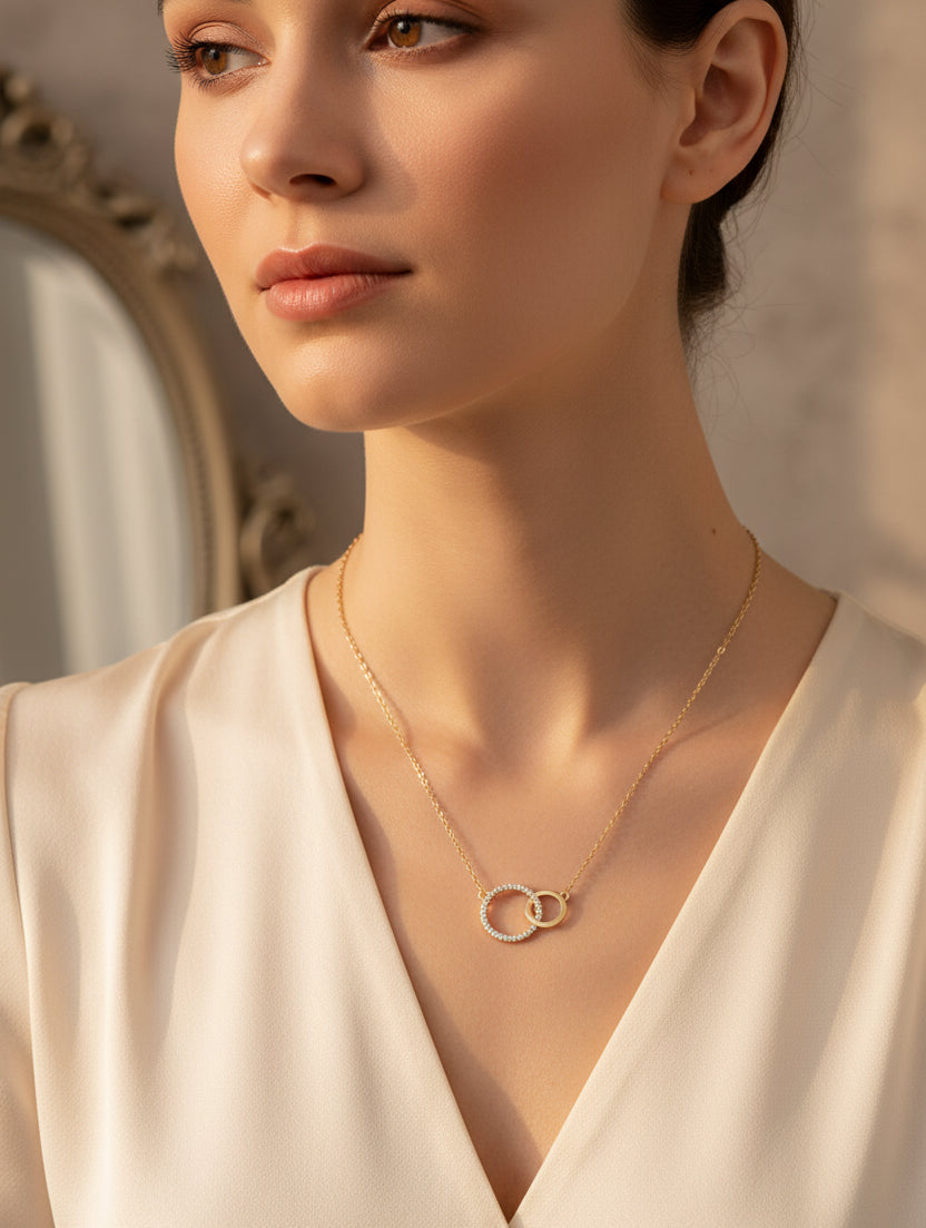 Gold necklace with interlocking rings on a blue background
