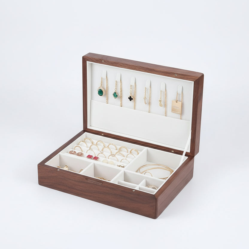 Wooden jewelry box with compartments holding earrings and rings, on a wooden surface.