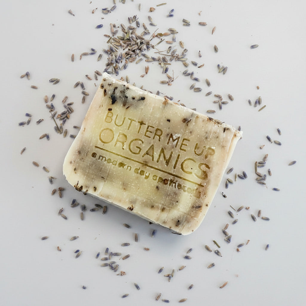 Bar of soap with 'Butter Me Up Organics' branding on a white background with lavender flowers.