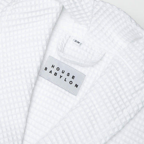 White textured garment with 'House Babylon' label on a white background