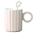 White ceramic mug with a star-shaped clip on a white background