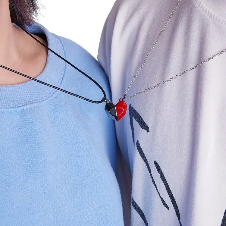 Two necklaces with heart pendants worn by people in blue and light gray shirts.
