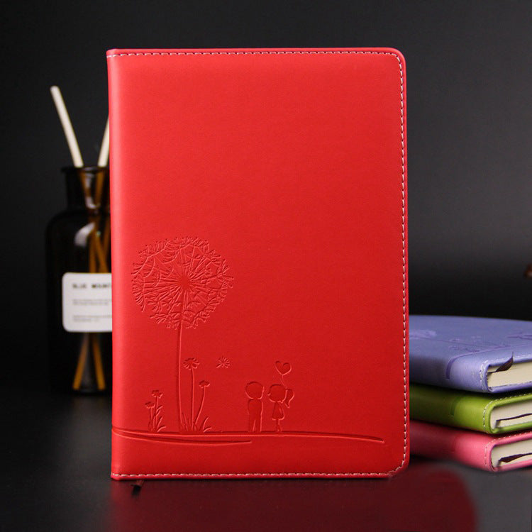 Red notebook with dandelion design on a dark background
