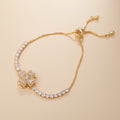 Gold bracelet with heart-shaped clasp on a soft pink background