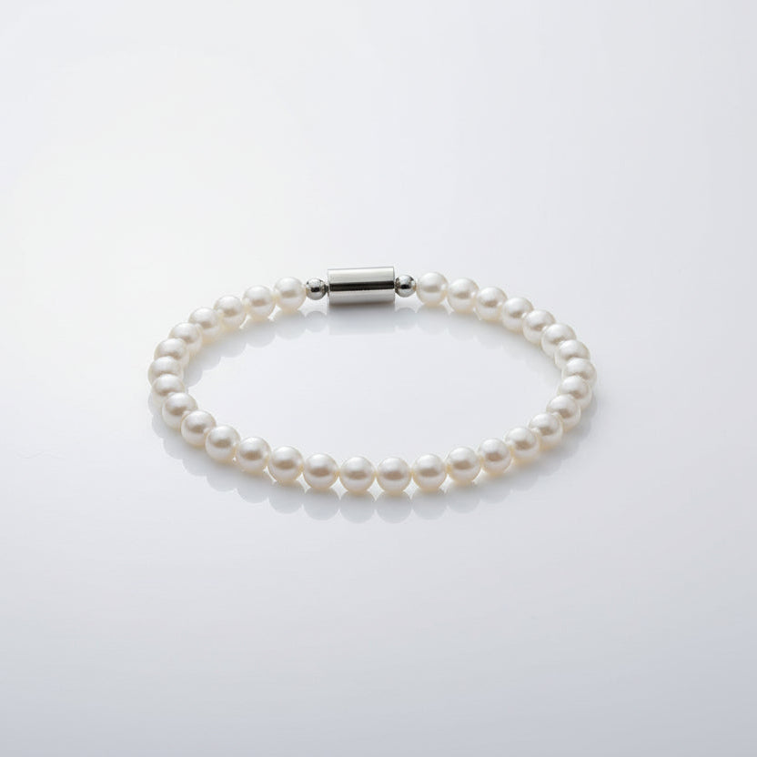 Pearl bracelet on a wrist with a neutral background