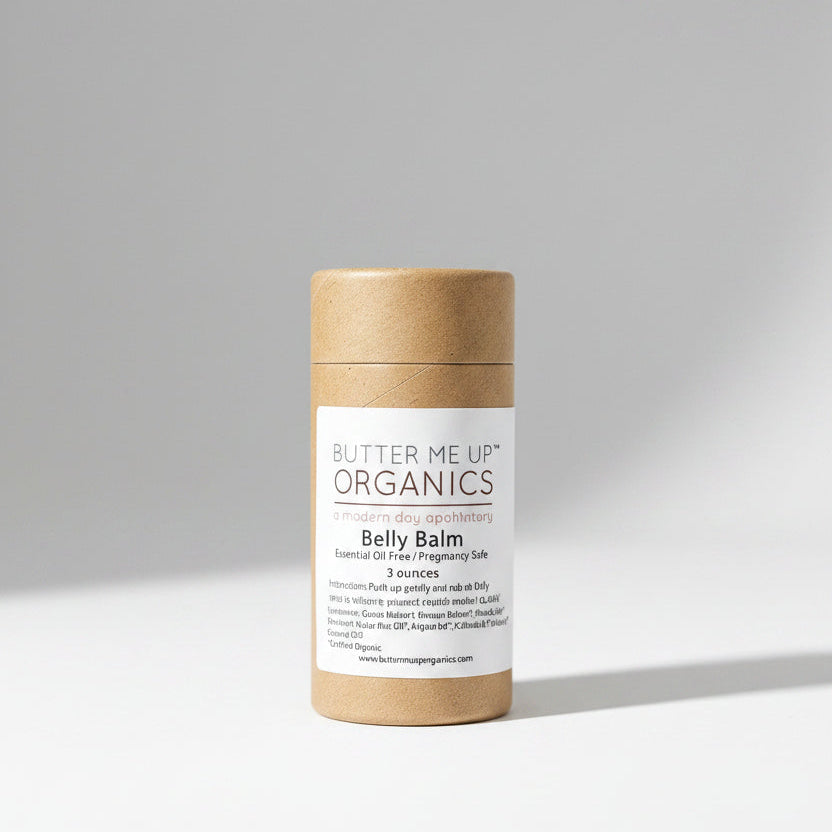 Butter Me Up Organics belly balm on a white plate with green leaves