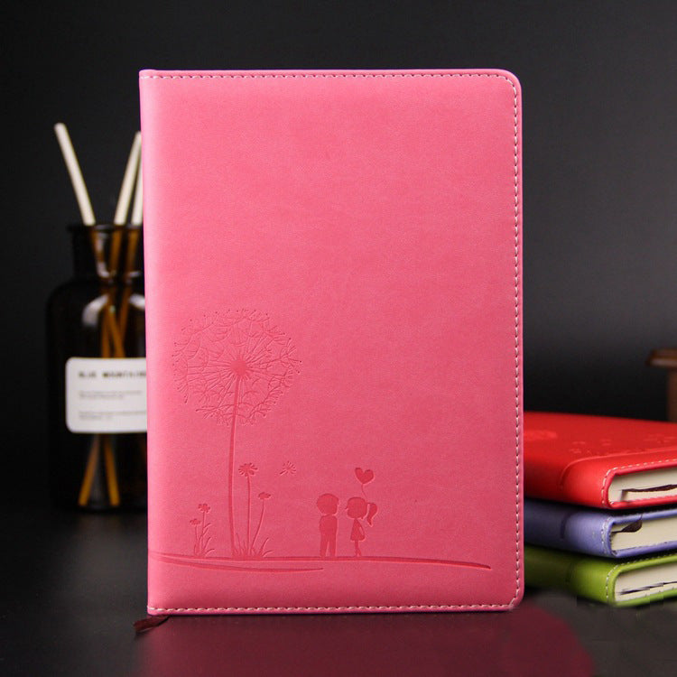 Pink notebook with dandelion design on a dark background