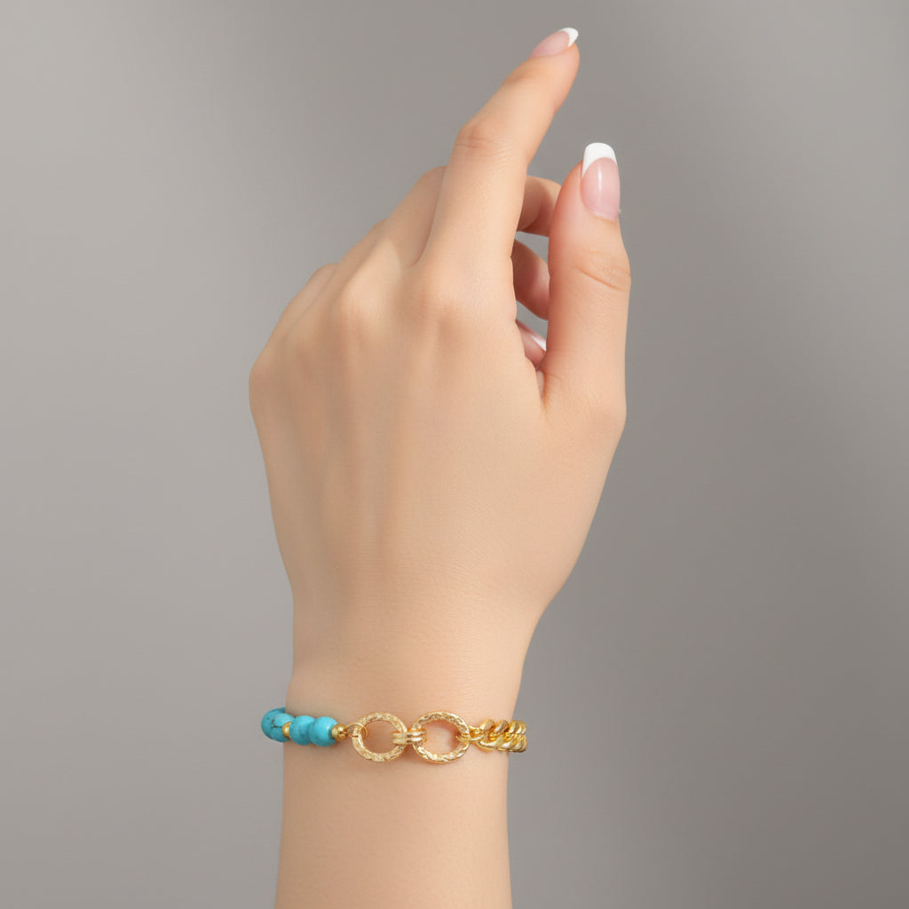 Bracelet with turquoise beads and gold chain on a white background