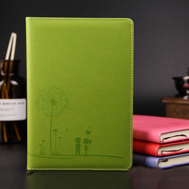 Green notebook with a dandelion design on a dark background