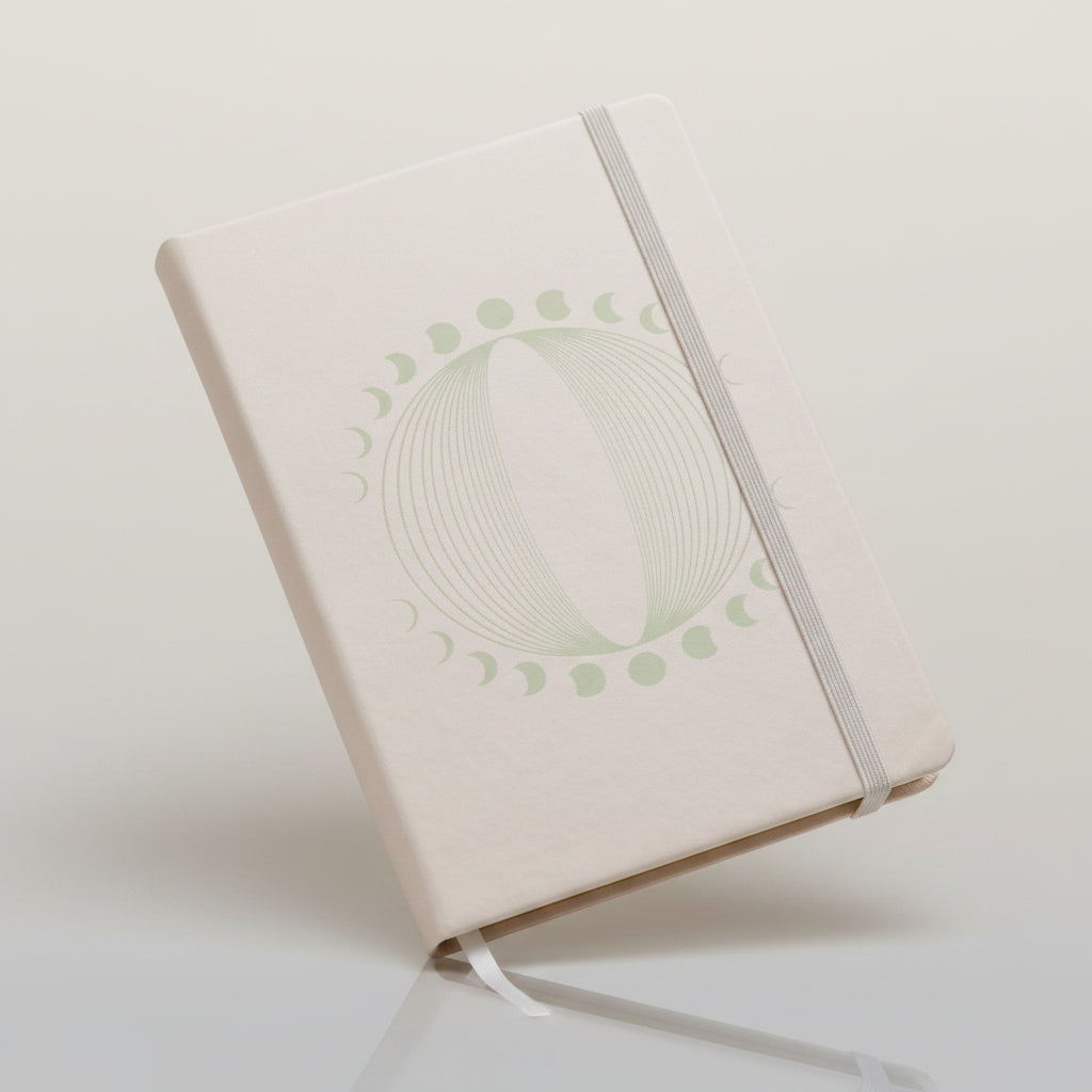 White notebook with decorative cover on a soft pink fabric background