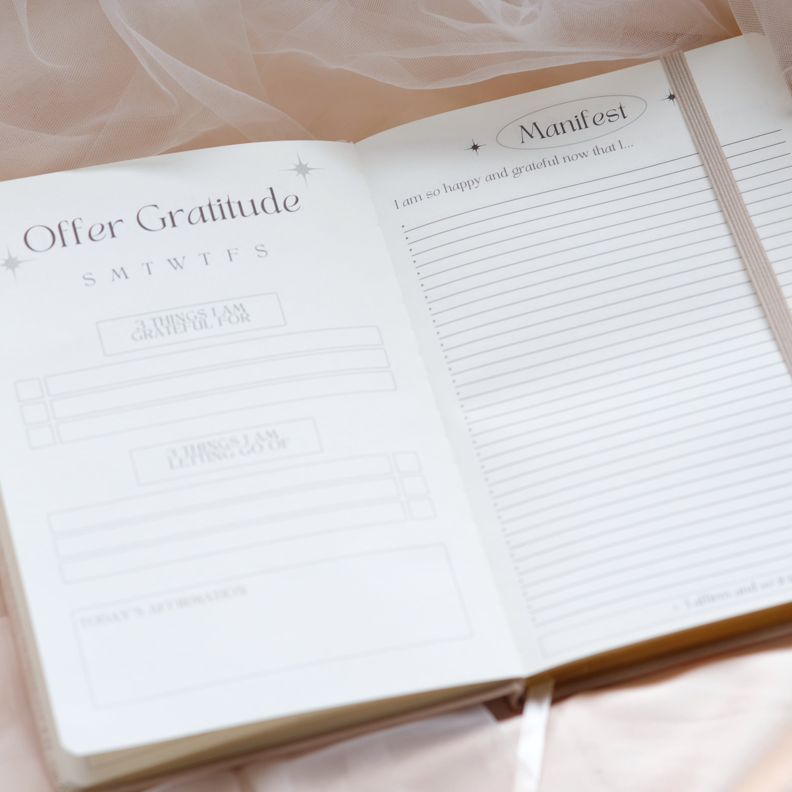 Open notebook with pages titled 'Offer Gratitude' and 'Manifest'